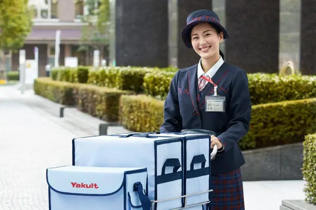Yakult Lady con su cargamento sonríe para la cámara
