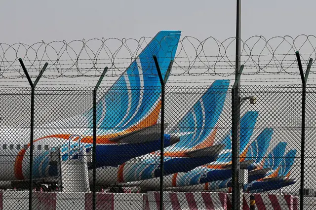 Una fila de aviones estacionados en el aeropuerto de Dubai