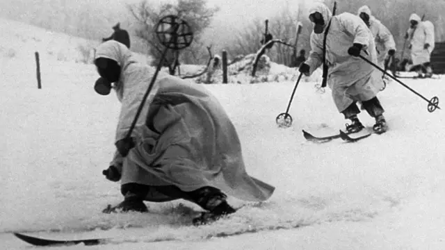 Tropas de esquí finlandesas, uniformadas de blanco y con máscaras antigases, se deslizan por la nieve en 1940 durante una preparación para la guerra.
