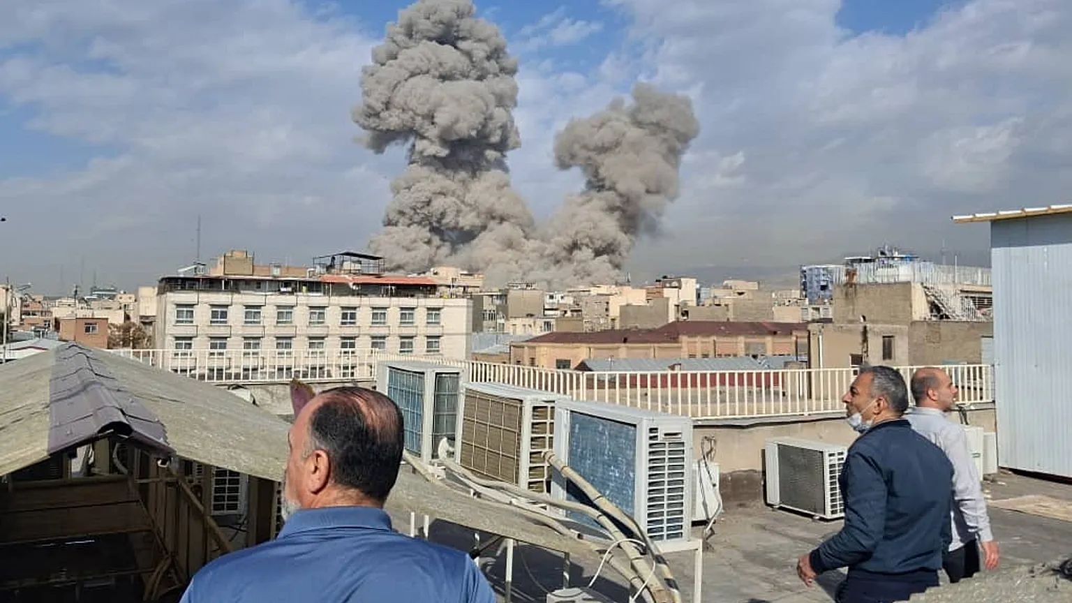People watch as smoke rises on the skyline after an explosion in Tehran, Iran, Saturday, Feb. 28, 2026.(AP Photo)