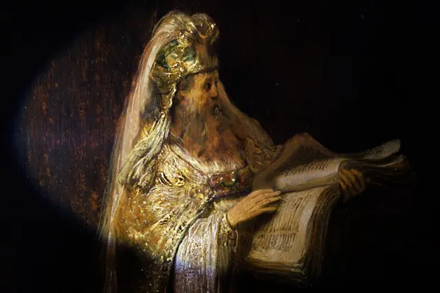 Detalle que muestra al sumo sacerdote Zacarías sosteniendo un libro y vistiendo túnicas ornamentadas en La visión de Zacarías en el templo de Rembrandt (1633)