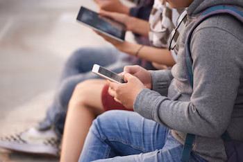 Varios adolescentes utilizando su móvil.