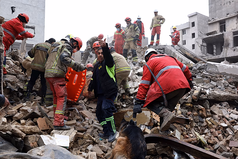 Rescue workers search for survivors in the rubble after a strike in southern Tehran, 13 March, 2026