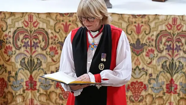 Mullally en una ceremonia leyendo.