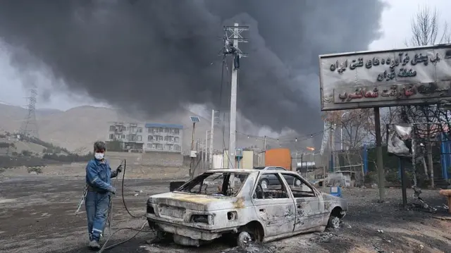 Columnas de humo se elevan sobre los tanques de un depósito de petróleo alcanzados por ataques conjuntos de Israel y Estados Unidos durante la noche del 8 de marzo de 2026 cerca de Teherán.