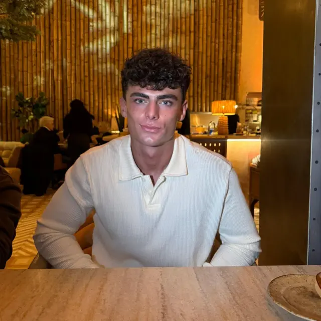 Tom sentado en una mesa en un restaurante.