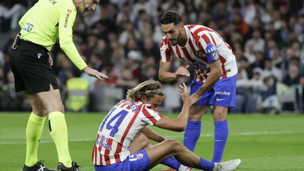Koke ayuda a Marcos Llorente tras sufrir un golpe durante el derbi
