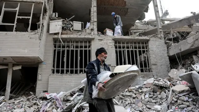 Un hombre camina entre los escombros de un edificio destruido por un ataque en Teherán, Irán (12 de marzo de 2026)