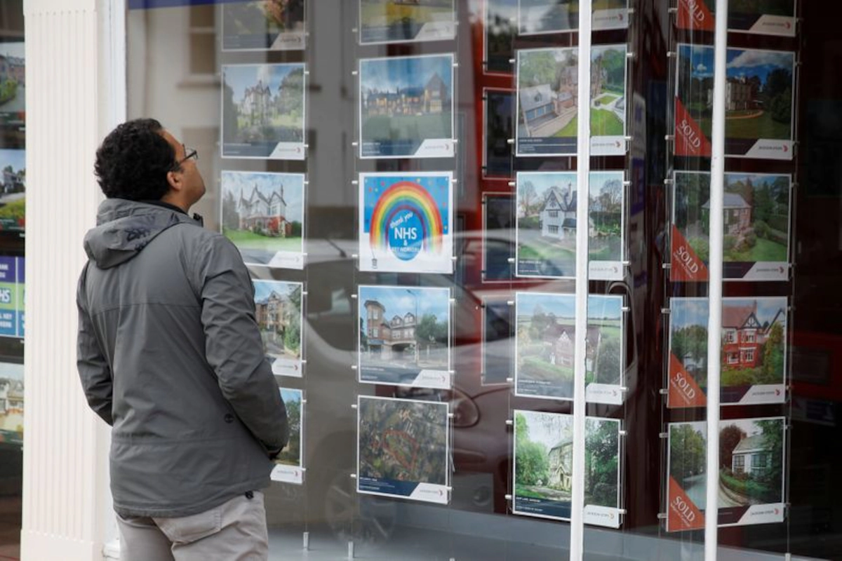 Un hombre mira el escaparate de una inmobiliaria con anuncios de viviendas en alquiler. REUTERS/Phil Noble/Foto de archivo