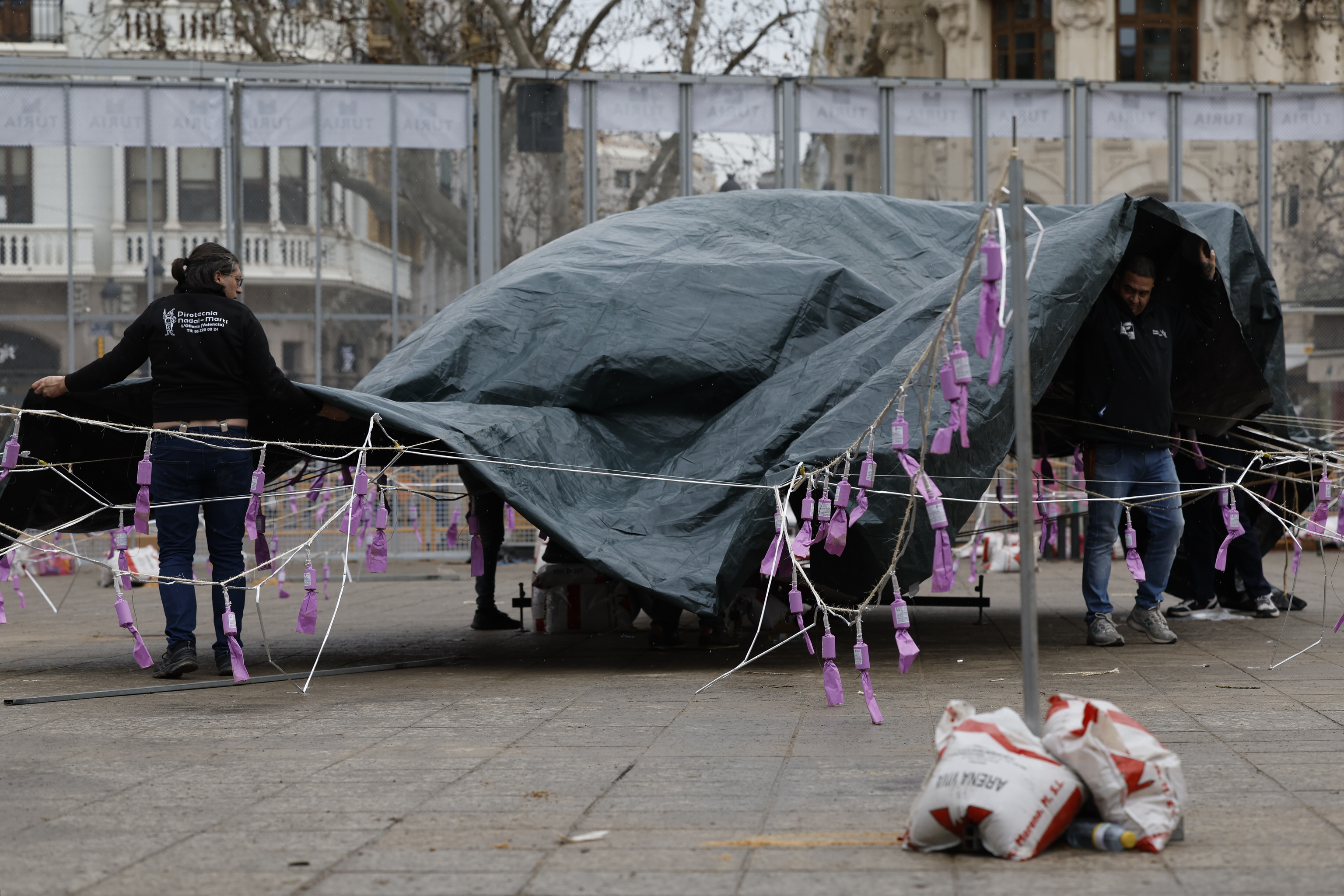 Operarios cubren la mascletá para protegerla de la lluvia ayer, en Comunitat Valenciana