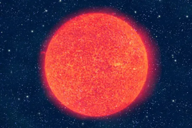 Una imagen de primer plano de una bola brillante de color naranja intenso en el espacio, con muchas estrellas distantes en el fondo oscuro.