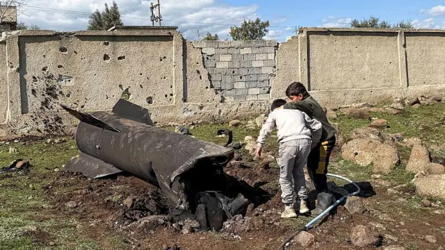 Niños sirios inspeccionan los restos de un cohete iraní que, según se informa, fue interceptado por las fuerzas israelíes en la zona rural meridional de Quneitra, cerca de Altos del Golán.