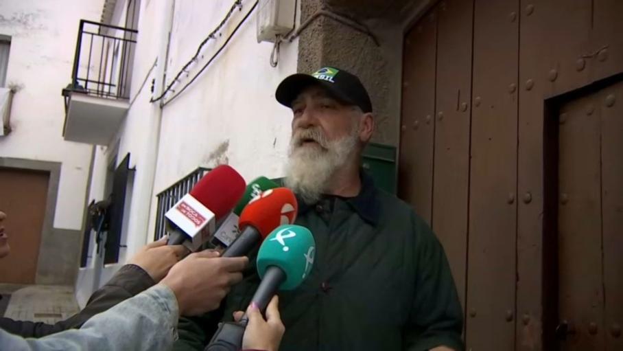 Uno de los dos hermanos, vecinos de la mujer desaparecida hace 9 años, en el portal de su vivienda, en Hornachos, tras prestar declaración ante la Guardia Civil.
