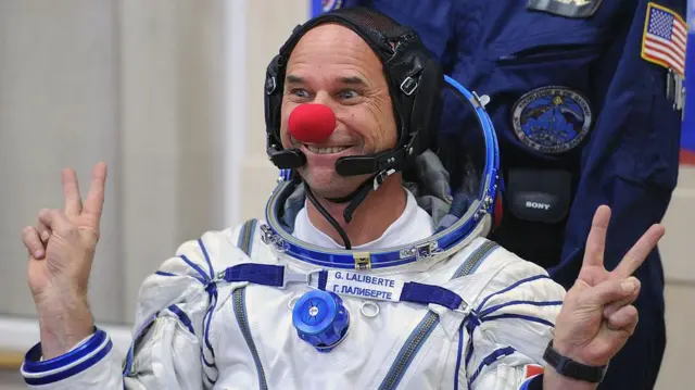 Guy Laliberté con una nariz roja de payaso y haciendo el signo de la victoria durante las pruebas del traje espacial antes de su lanzamiento a la Estación Espacial Internacional en 2009..