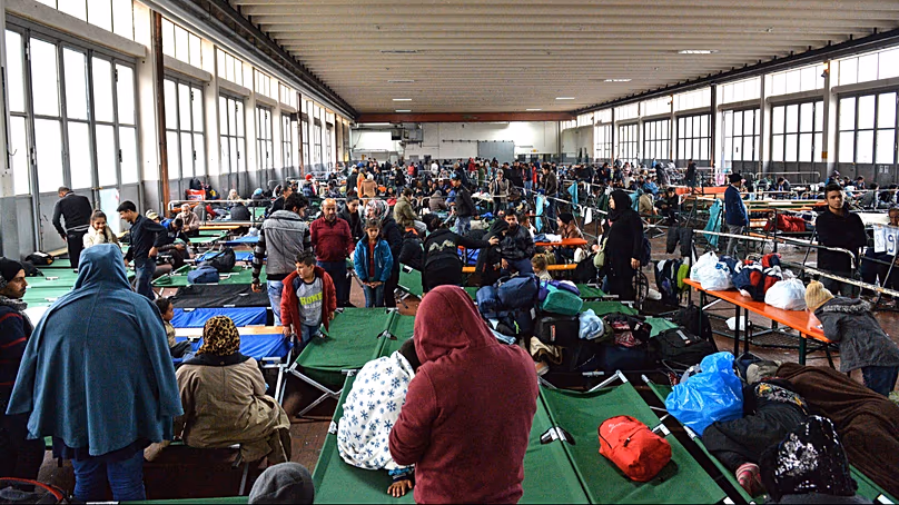 Refugees wait in a crowded migrant registration center in Germany, Oct. 8, 2015. (AP Photo/Kerstin Joensson, File)