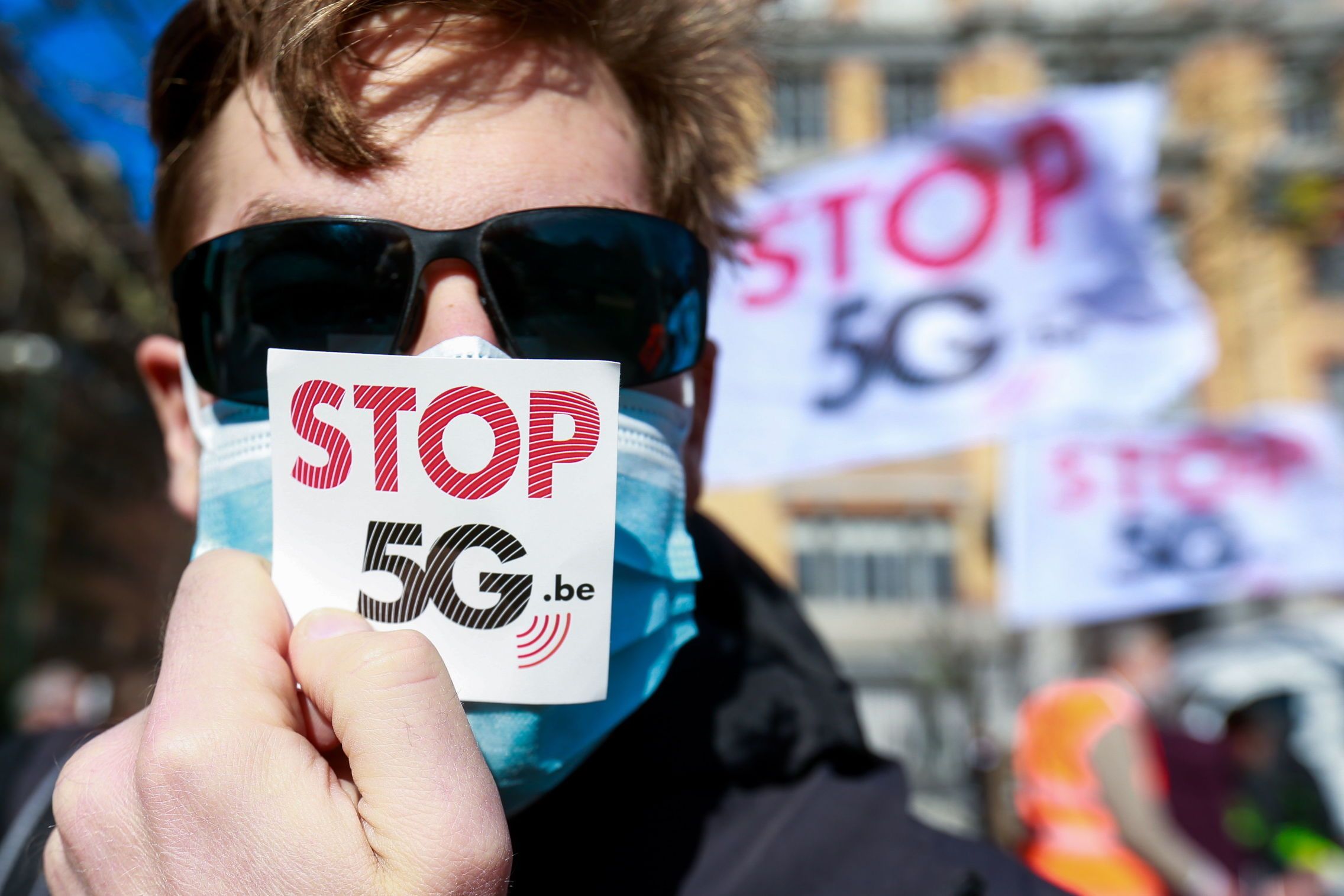 Un miembro del colectivo stop5G.be sostiene una pegatina frente al Ministerio de Justicia de Bruselas en febrero de 2021. (EFE/Stephanie Lecocq)