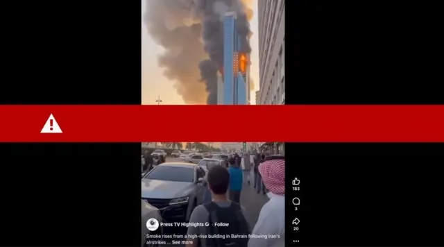 La captura de pantalla de un video, generado por IA, muestra un rascacielos en llamas con columnas de humo saliendo de él. Una multitud de personas mira hacia el edificio.