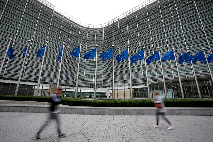 FILE - European Union flags flap in the wind as pedestrians walk by EU Commission in Brussels, Belgium, Sept. 20, 2023.
