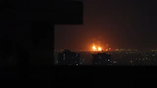 El humo se eleva desde la refinería de petróleo de Teherán después de los ataques aéreos en Teherán, Irán, el 7 de marzo de 2026. El horizonte está iluminado por las llamas que se elevan desde la refinería.