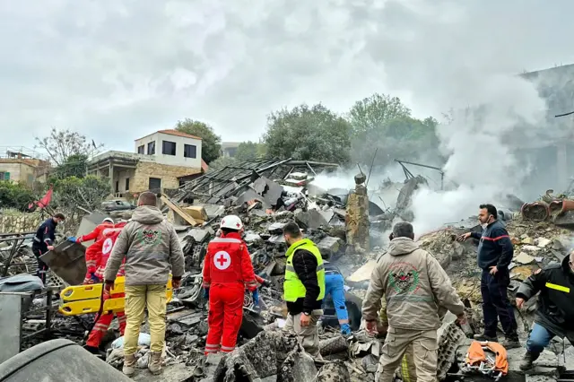 Equipos de emergencia trabajan entre escombros humeantes tras un ataque israelí en el sur del Líbano.