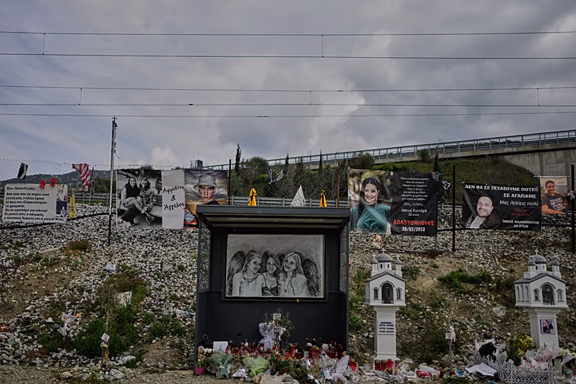 Banners, portraits and miniature churches are placed in memory of the victims at the site of the Tempi train disaster in Tempi, 23 March, 2026