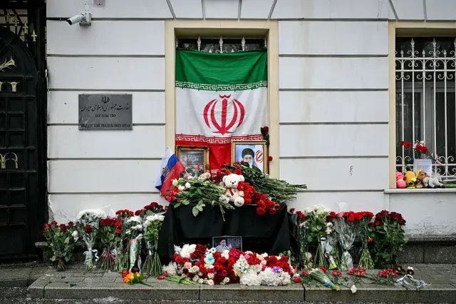 Ramos de flores frente a la entrada de la embajada de Irán en Moscú con la foto del líder supremo, ayatolá Alí Jamenei, y las banderas de Irán y Rusia