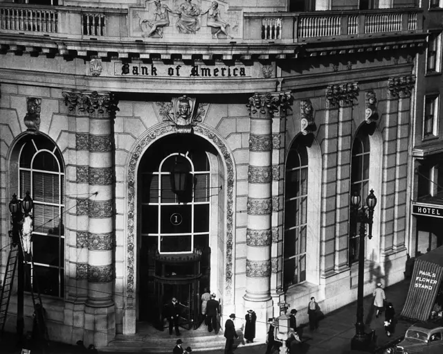 Entrada imponente al banco, con gente en la calle