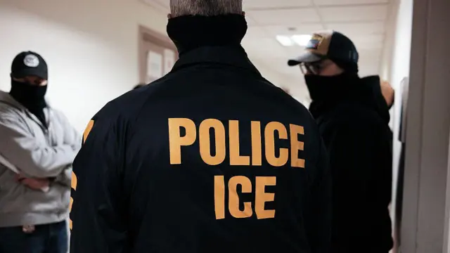 Agentes de ICE en un pasillo, con las caras cubiertas