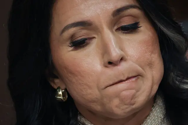 Tulsi Gabbard, en primer plano, se muerde un labio.
