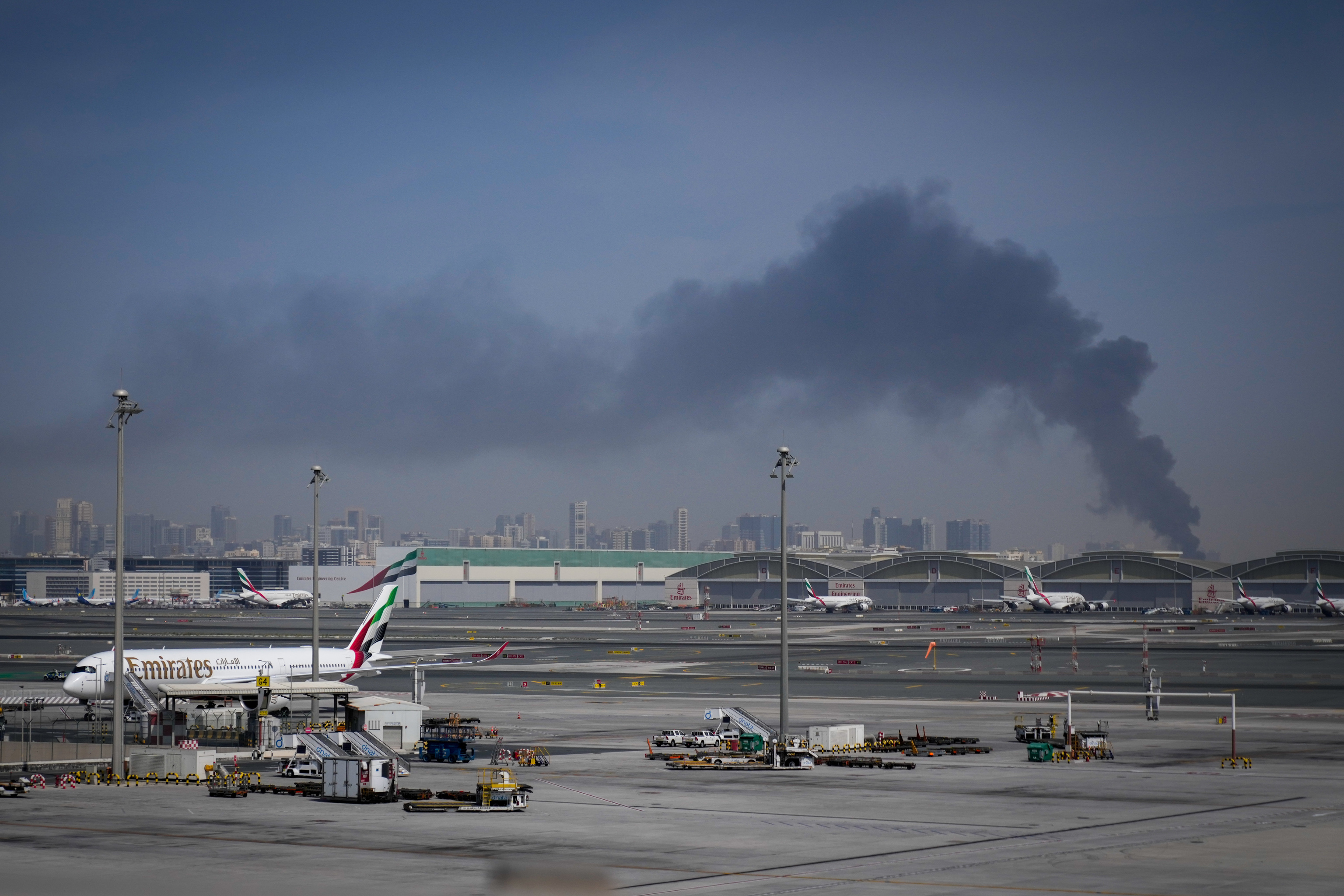 Imagen del Aeropuerto Internacional de Dubai, al fondo una columna de humo fruto de un ataque aéreo.