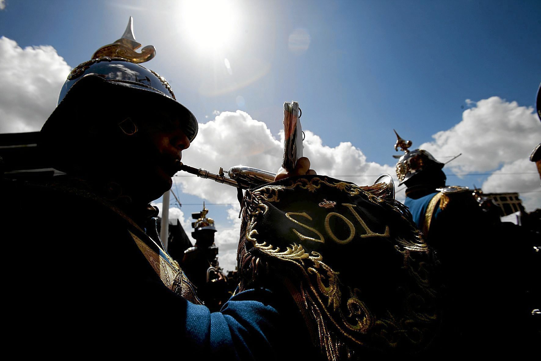 Un paso de Semana Santa procesiona bajo un sol radiante.