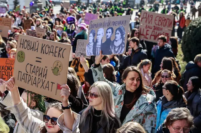 Personas portan pancartas en las que se reclama la protección de los derechos de las mujeres durante en Kiev, Ucrania.