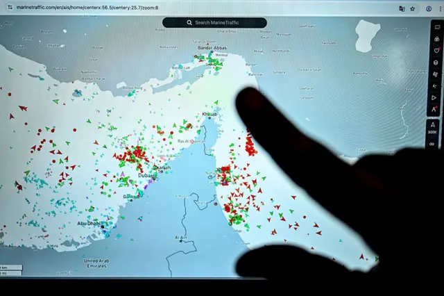 Mapa donde un dedo señala el estrecho de Ormuz