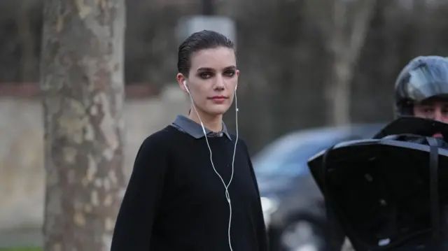 Una mujer con auriculares con cable.