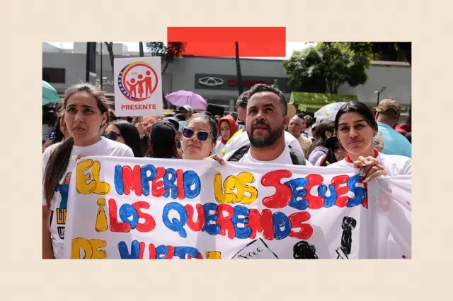 Cuatro personas llevan una pancarta en una protesta. Todas llevan camisetas blancas.
