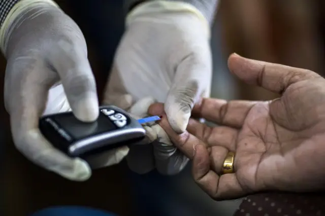 Un trabajador de la Fundación de Salud Pública en India le realiza una prueba de glucosa en sangre a un paciente durante un programa gratuito de detección puerta a puerta, financiado por Eli Lilly & Co., en una vivienda de la aldea agrícola de Thana Kalan, en Haryana (India).