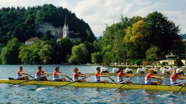 Matt Brittin como parte de un equipo de ocho en plena acción durante una competencia de remo en el lago Bled, Eslovenia, del Campeonato Mundial de Remo
