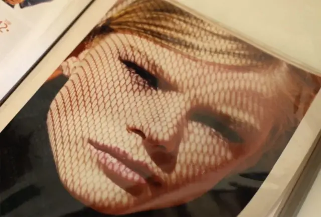 Fotografía de un álbum que muestra un retrato artístico de una joven rubia que mira a la cámara.