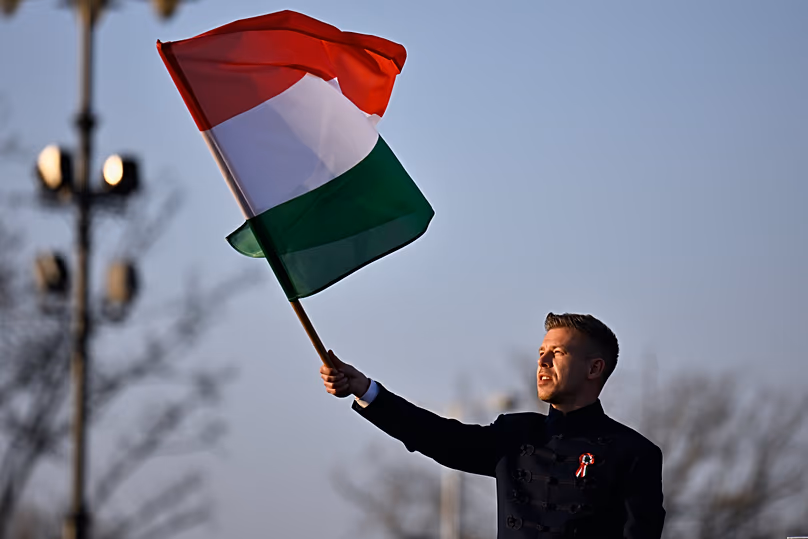 Opposition leader Péter Magyar waves a flag during a march in Budapest, 15 March, 2026