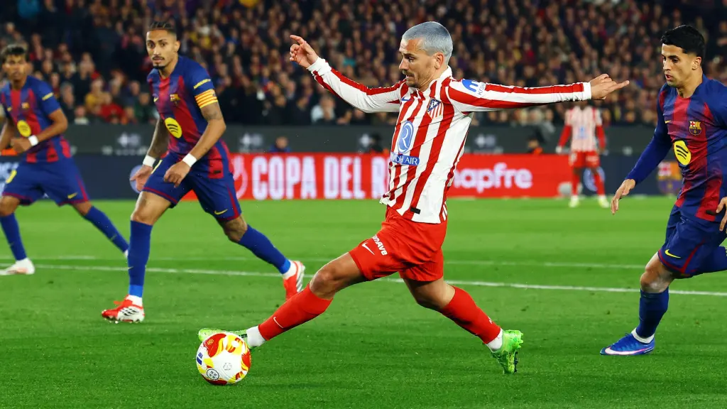 Griezmann conduce el balón presionado por Cancelo.