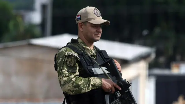 Un militar de las Fuerzas Armadas de Paraguay vigila con un arma en la mano.