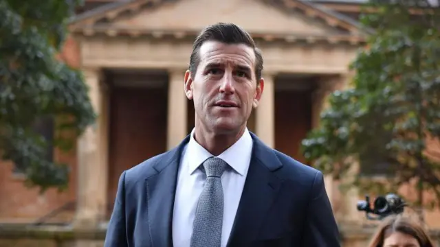Roberts-Smith vestido de traje a las puertas de una corte de Australia.