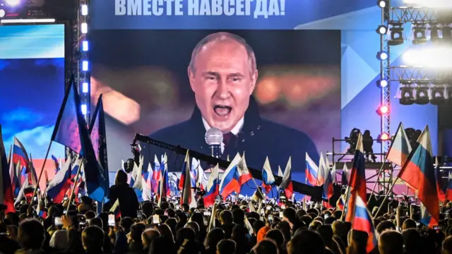 El presidente de Rusia, Vladimir Putin, visto en una pantalla en la Plaza Roja durante una alocución