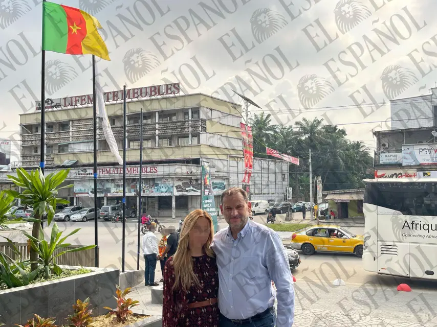 José Luis Ábalos y Andrea de la Torre, posan frente a la bandera de Camerún en una calle de Douala.