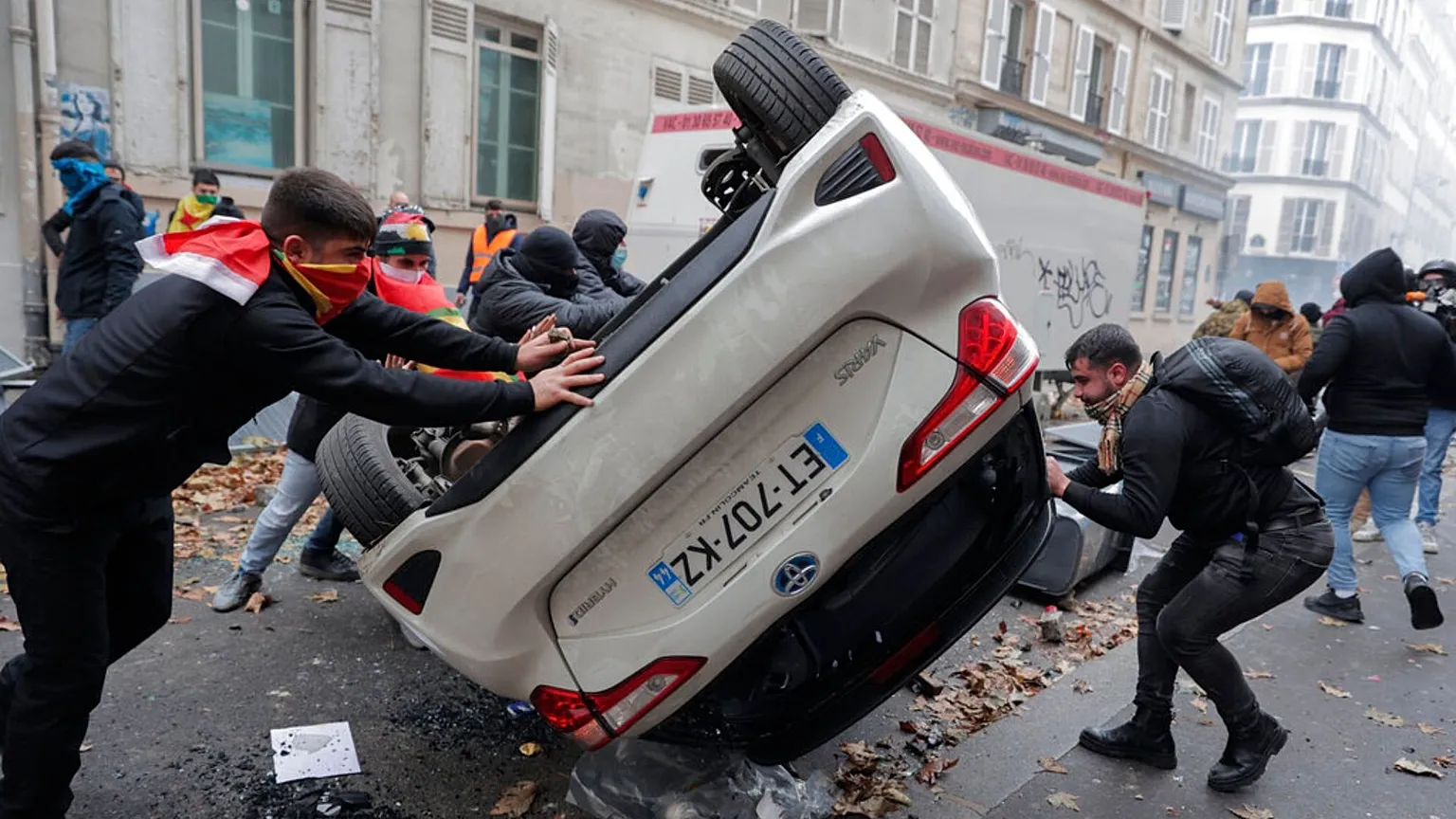 FILE - Demonstrators turn a car over during a protest against the shooting at the Kurdish culture centre in Paris, 24 December 2022.