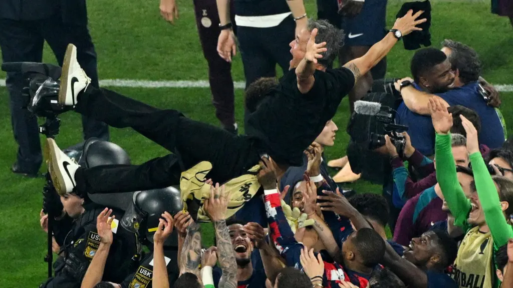 Los jugadores del PSG mantean a Luis Enrique.