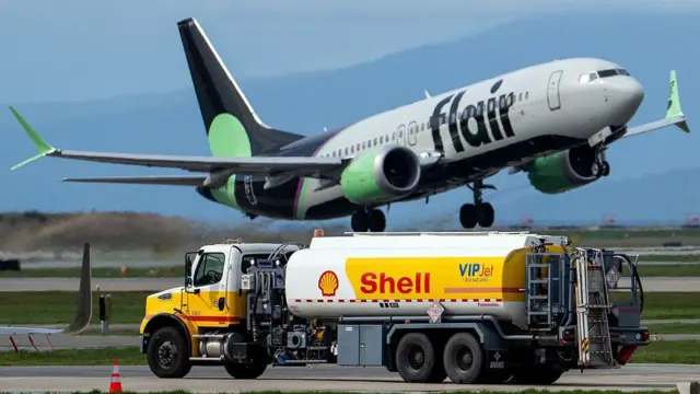 Avión volando sobre un camión cisterna
