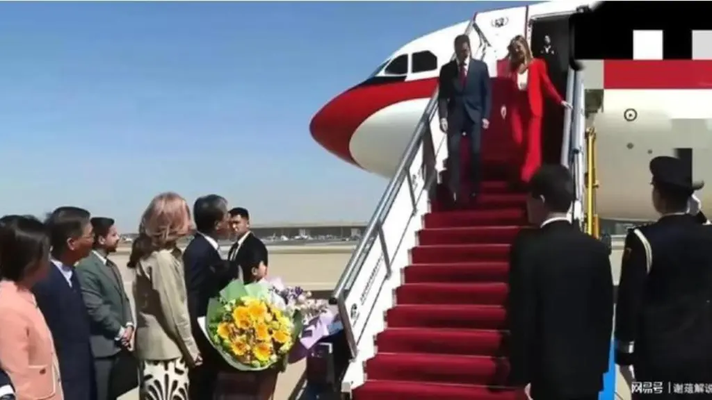 El ministro de Educación chino recibe a Pedro Sánchez y Begoña Gómez al pie de la escalerilla, el sábado en el aeropuerto de Pekín.
