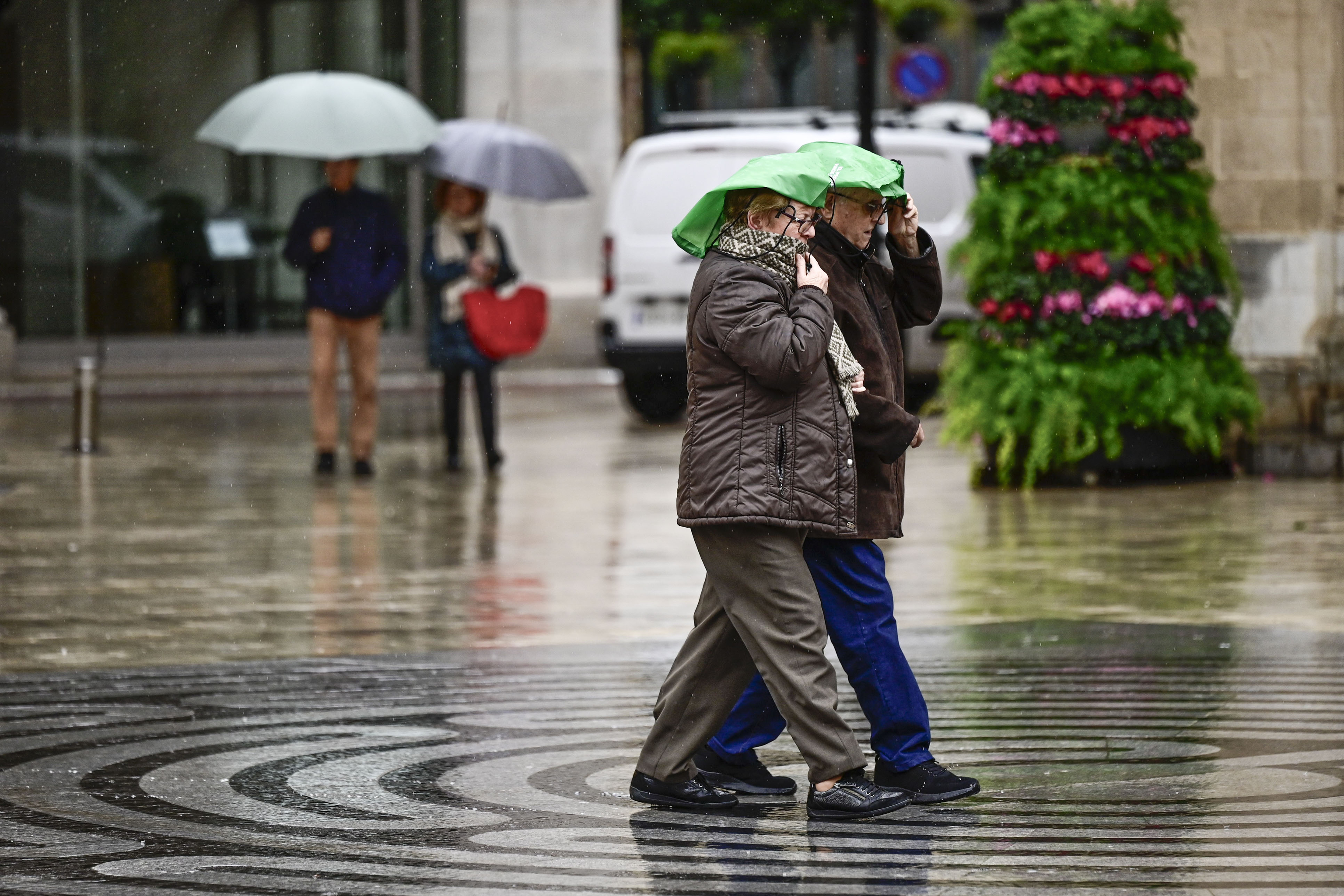 Varias personas caminan bajo la lluvia en Castellón.