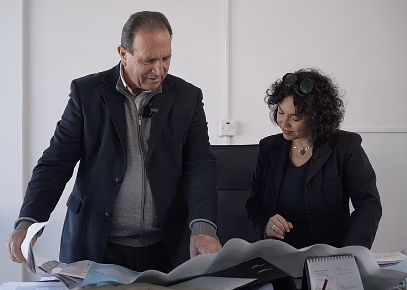 Deputy Mayor of Akrotiri Giorgos Kostantinou showing reporter Monica Pinna the proximity of his village to the British Royal Airforce Base of Akrotiri